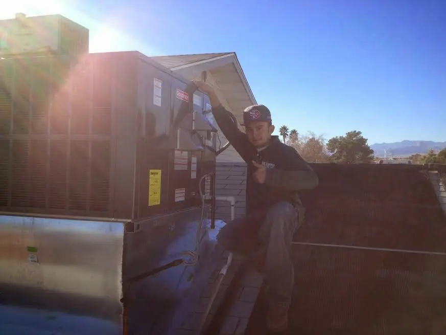 HVAC technician performing HVAC Inspection on a rooftop unit in Lake Mathews